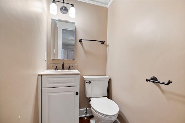 half bathroom featuring crown molding, vanity, toilet, and baseboards