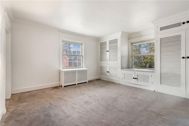 unfurnished bedroom featuring carpet, two closets, radiator heating unit, ornamental molding, and multiple windows