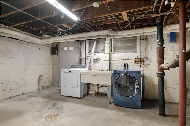 unfinished basement with a sink and separate washer and dryer