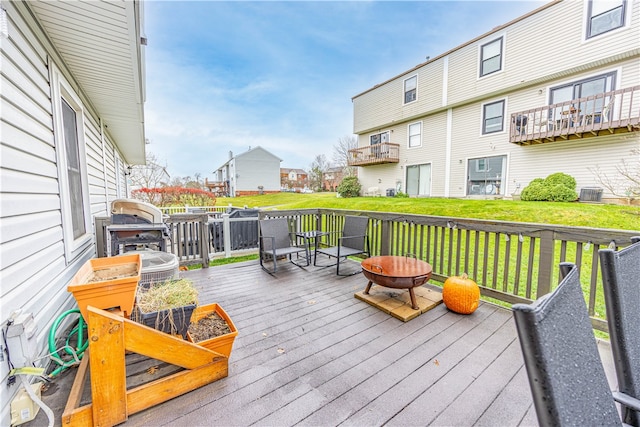 wooden deck featuring central AC unit and a lawn