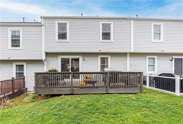 rear view of house featuring a wooden deck and a yard