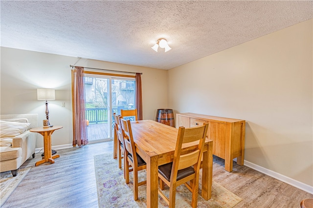 dining room with a textured ceiling and light wood-type flooring