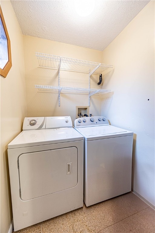 washroom with independent washer and dryer and a textured ceiling