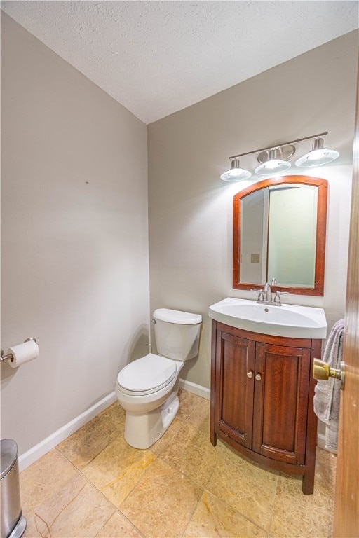 bathroom featuring vanity, a textured ceiling, and toilet