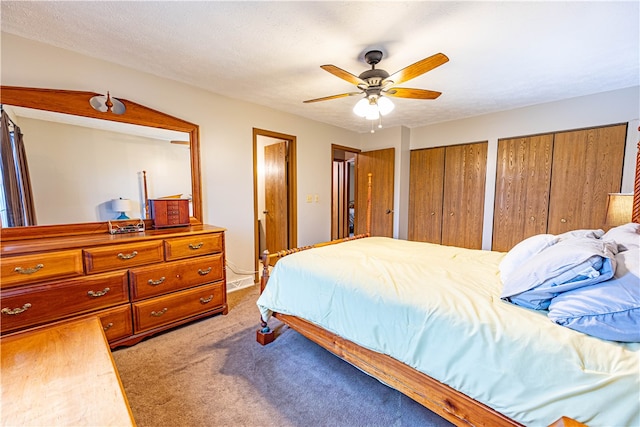 carpeted bedroom featuring ceiling fan and a textured ceiling