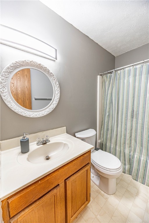 full bathroom with vanity, toilet, shower / bathtub combination with curtain, and a textured ceiling