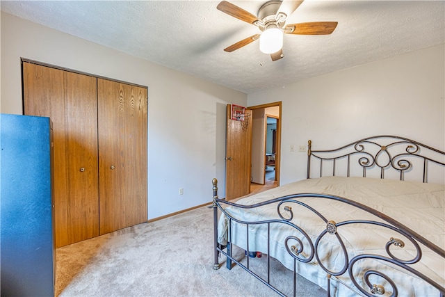 carpeted bedroom featuring ceiling fan, a textured ceiling, and a closet