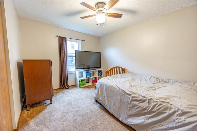 carpeted bedroom with ceiling fan and a textured ceiling