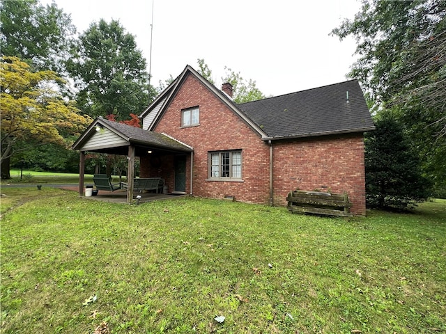 rear view of house with a lawn, an outdoor living space, and a patio