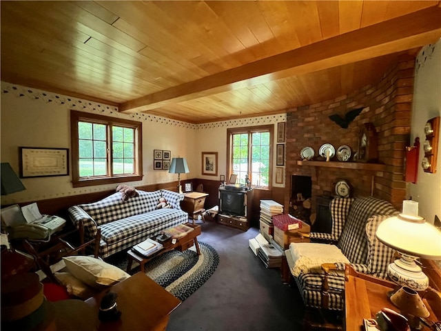 sitting room featuring beamed ceiling, plenty of natural light, wooden ceiling, and a brick fireplace