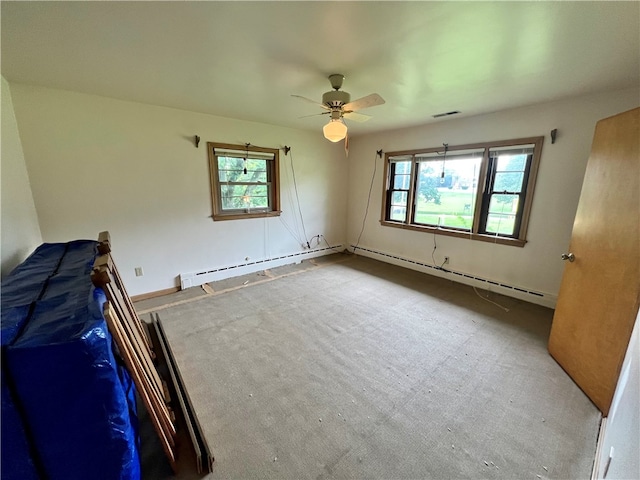 unfurnished bedroom with carpet flooring, multiple windows, ceiling fan, and a baseboard radiator