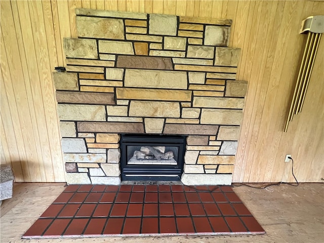 room details featuring a fireplace and wooden walls