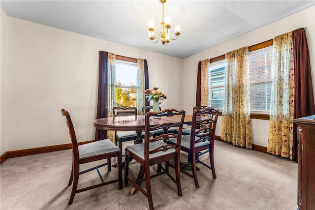 dining area with light carpet and a notable chandelier