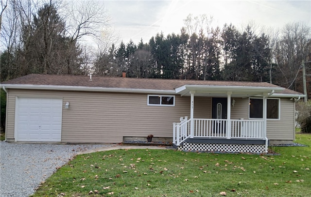 view of front of property featuring covered porch, a garage, and a front yard