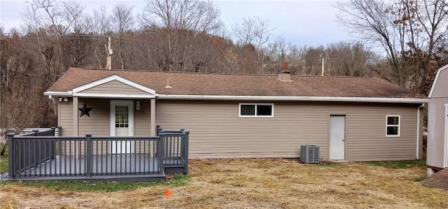 rear view of house with a lawn, a deck, and central AC