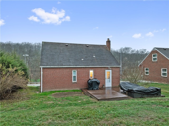 rear view of house with a yard and a deck