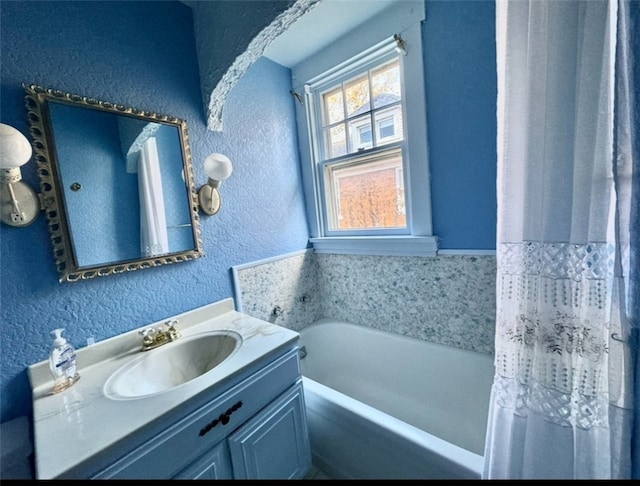 bathroom with vanity and a tub