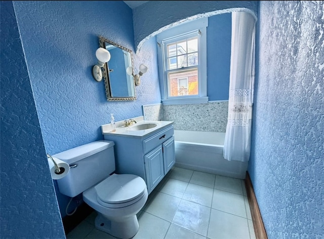 bathroom featuring tile patterned floors, a washtub, vanity, and toilet