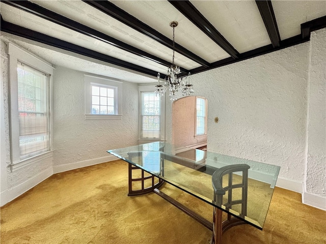 carpeted dining space with beam ceiling and a notable chandelier