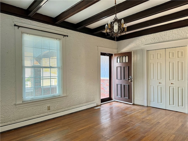 foyer featuring beam ceiling, baseboard heating, a notable chandelier, and wood-type flooring