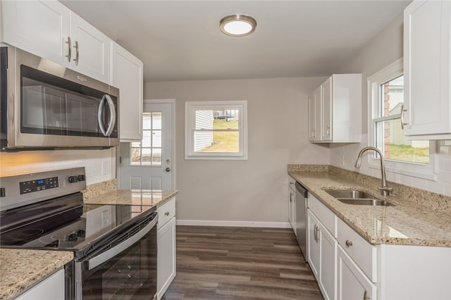 kitchen featuring sink, dark hardwood / wood-style floors, appliances with stainless steel finishes, light stone counters, and white cabinetry