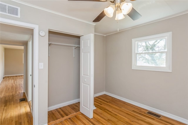 unfurnished bedroom featuring ceiling fan, a closet, and wood-type flooring