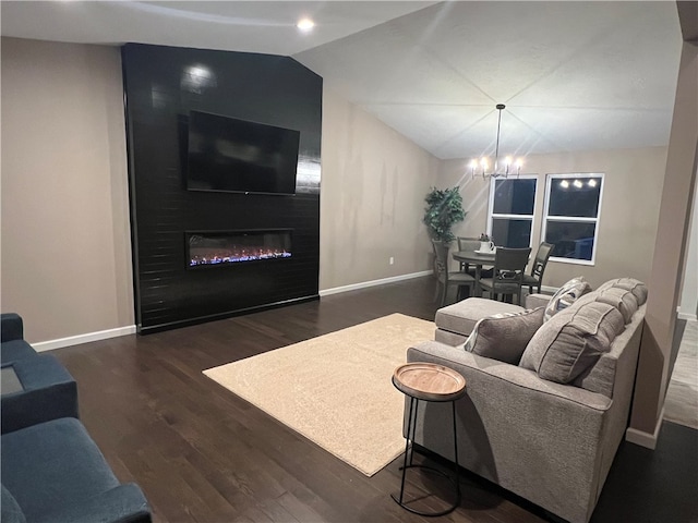 living room featuring dark hardwood / wood-style floors, lofted ceiling, a fireplace, and a chandelier