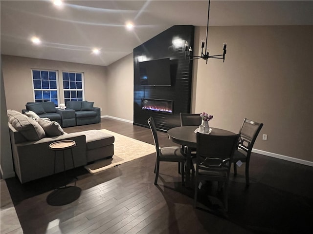 living room with a large fireplace, a chandelier, and hardwood / wood-style flooring