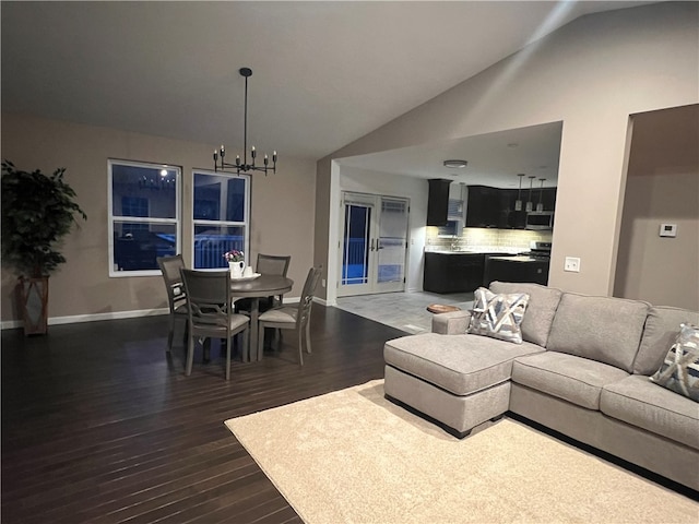 living room with a chandelier, dark wood-type flooring, and vaulted ceiling