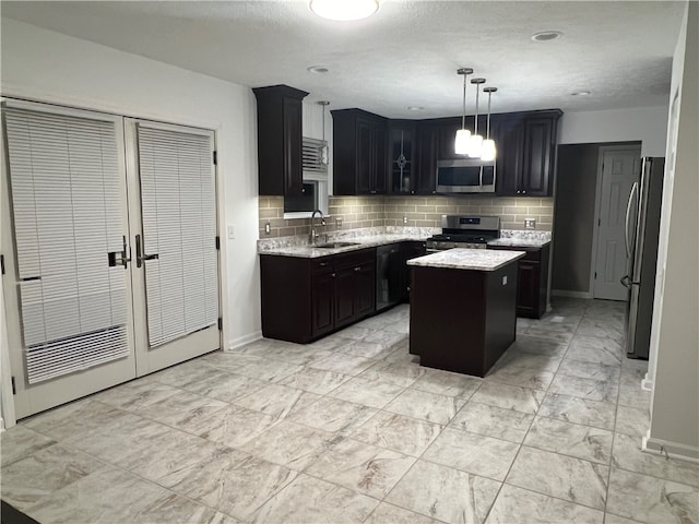 kitchen featuring decorative backsplash, a kitchen island, hanging light fixtures, and appliances with stainless steel finishes