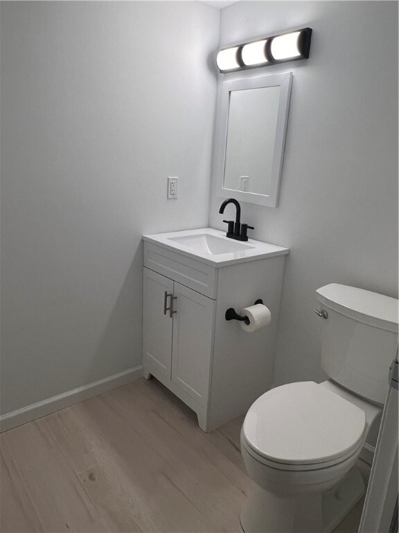 bathroom featuring vanity, toilet, and wood-type flooring