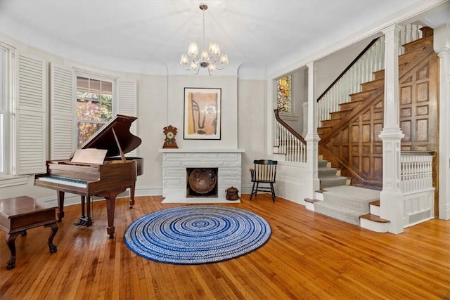 sitting room with a fireplace, hardwood / wood-style flooring, and a notable chandelier