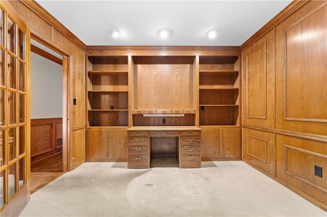 carpeted home office featuring wooden walls