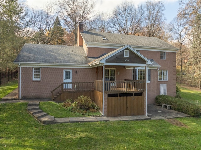 rear view of house featuring a wooden deck and a lawn