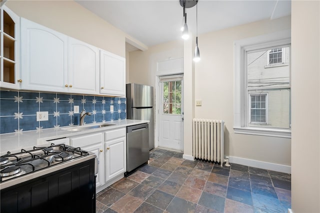 kitchen featuring radiator, white cabinets, sink, stainless steel dishwasher, and range