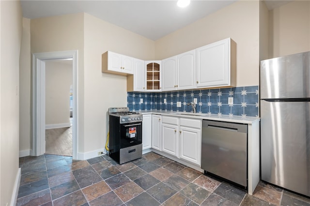 kitchen featuring decorative backsplash, stainless steel appliances, white cabinetry, and sink