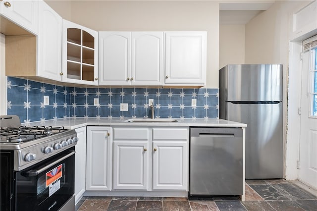 kitchen with decorative backsplash, sink, white cabinetry, and stainless steel appliances