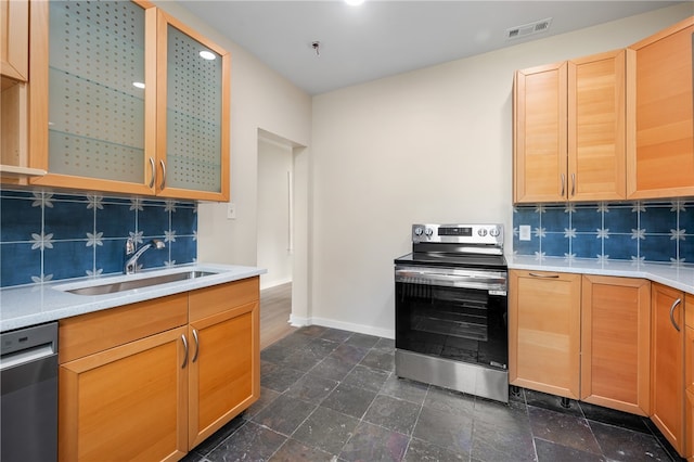 kitchen with appliances with stainless steel finishes, tasteful backsplash, and sink