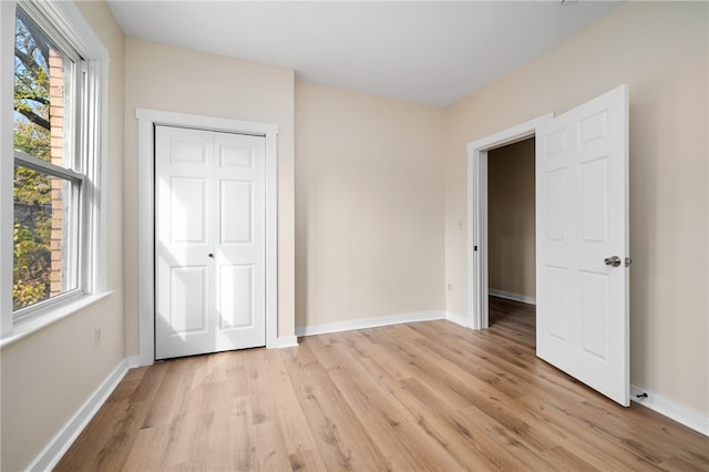 unfurnished bedroom with a closet and light hardwood / wood-style flooring