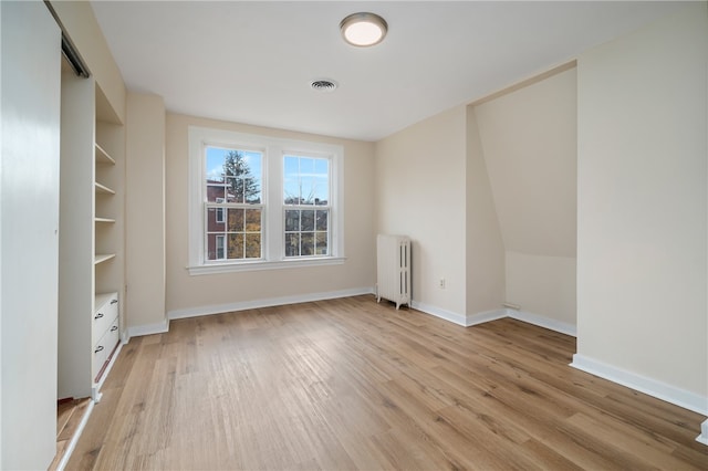 unfurnished room featuring light wood-type flooring and radiator