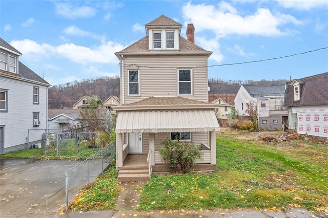 back of house featuring a lawn and covered porch