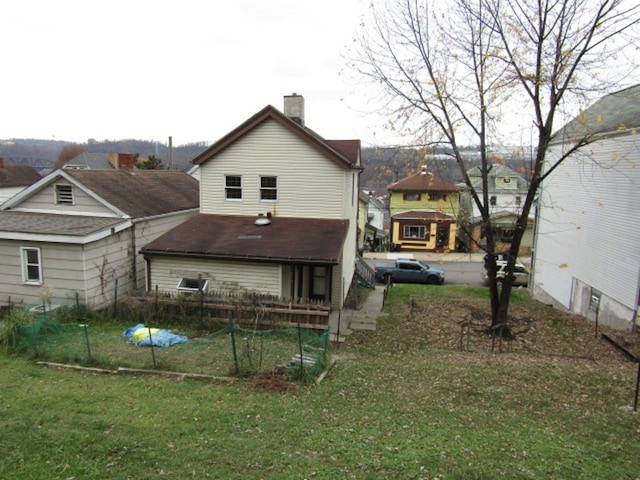 rear view of property featuring a lawn