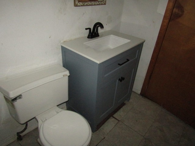 bathroom featuring tile patterned flooring, vanity, and toilet