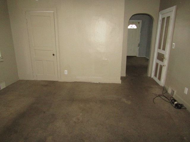 unfurnished room with dark carpet