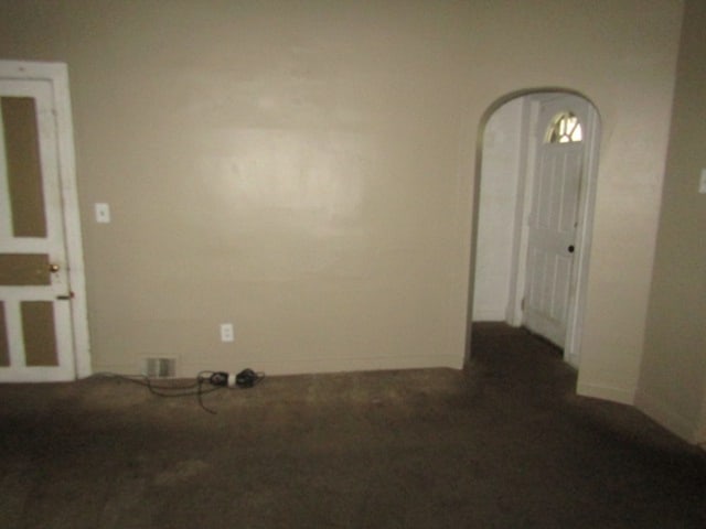 unfurnished room with dark carpet