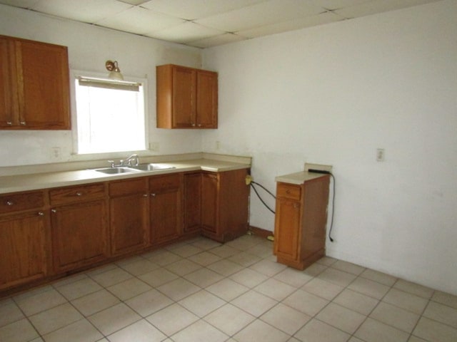 kitchen featuring light tile patterned flooring, a paneled ceiling, and sink