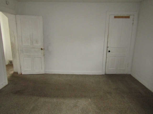 spare room featuring dark carpet