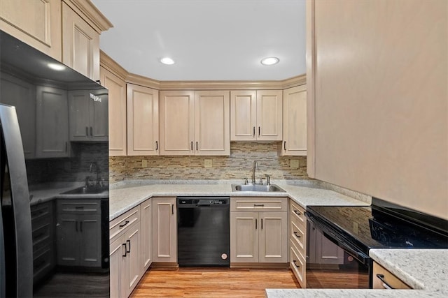 kitchen featuring decorative backsplash, sink, light hardwood / wood-style floors, and black appliances