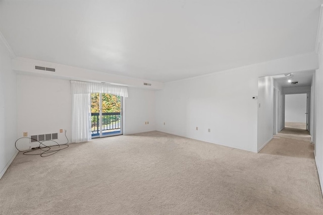 empty room featuring light colored carpet and crown molding