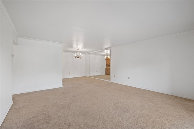 carpeted empty room with crown molding and a notable chandelier